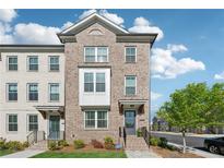 Charming brick townhouse with well-manicured front yard and inviting entrance at 1621 Wellborn Walk, Suwanee, GA 30024
