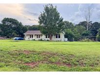 Charming single-story home with a spacious lawn, mature trees, and a welcoming front porch at 107 Bowen Rd, Stockbridge, GA 30281