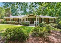 Charming single-story brick home featuring a covered front porch and beautifully landscaped front yard at 1135 Timberland Se Dr, Marietta, GA 30067