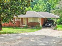 Cozy single-story brick home featuring a front lawn, carport, and easy driveway access at 1900 Columbia Dr, Decatur, GA 30032