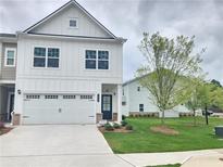 Charming two-story home with a two-car garage and a well-manicured lawn at 1177 Chastain Dr, Sugar Hill, GA 30518