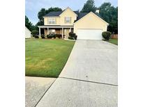 Charming two-story home with a well-manicured lawn and a spacious driveway at 4237 Webb Meadows Dr, Loganville, GA 30052