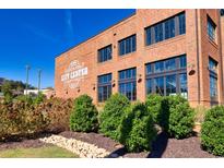 Brick building with 'City Center' signage, complemented by manicured landscaping and bright blue skies at 4625 Greyson Manor Dr, Cumming, GA 30041