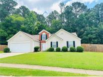 Charming single-story home with well-manicured lawn and attached two-car garage at 6214 Treeridge Nw Dr, Acworth, GA 30101