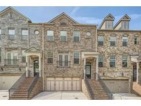 Charming townhome with brick exterior, two-car garage, and inviting entrance staircase at 2433 Santa Rosa St, Alpharetta, GA 30009