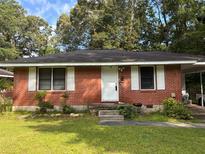 Charming single-story red brick home with a well-maintained front yard and white shutters at 4513 College St, Forest Park, GA 30297