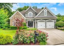 Charming home featuring a stone facade, well-manicured lawn and a two-car garage at 1473 Cardova Pointe, Dunwoody, GA 30338