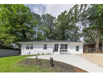 Charming exterior view of a newly renovated single-story home with a well-manicured lawn and a private driveway at 2899 Gresham Se Rd, Atlanta, GA 30316
