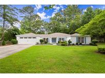 Charming single-story home with lush green lawn, blue shutters, and a two-car garage at 3545 Turtle Cove Se Ct, Marietta, GA 30067