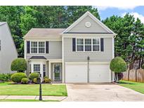 Charming two-story home featuring a manicured lawn, a two-car garage and traditional architectural details at 585 Ashland Pkwy, Woodstock, GA 30189