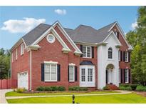 Charming brick home featuring manicured lawn, black shutters and white trim at 650 Garden Wilde Pl, Roswell, GA 30075