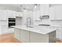 Bright kitchen with white cabinets, stainless steel appliances, and center island with quartz countertop at 1915 Redfield Ne Dr, Marietta, GA 30066