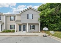 Charming townhome with gray siding, black shutters, and covered front porch, complemented by lush greenery at 4001 Avalon Sw Rd, Atlanta, GA 30331