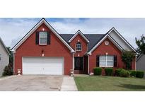 Charming red brick home with a well-manicured lawn and two-car garage in a suburban neighborhood at 2645 Barkley Manor Dr, Lawrenceville, GA 30044