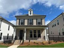 Charming two-story home with gray brick, a welcoming front porch, and professional landscaping at 163 Basil St, Cumming, GA 30040