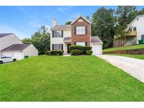 Charming two-story home with brick and siding exterior, manicured lawn and driveway at 6481 Alford Way, Lithonia, GA 30058
