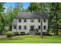 Charming two-story home with symmetrical windows, gray shutters, and a well-maintained front yard and garden at 7110 Northgreen Dr, Atlanta, GA 30328