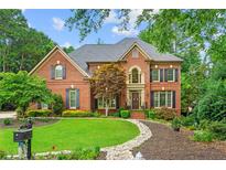 Charming two-story brick home featuring manicured lawn and mature landscaping at 130 Silver Mist Cir, Alpharetta, GA 30022