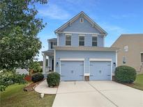 Charming two-story home with a two-car garage, blue siding, and a well-manicured lawn, creating an inviting curb appeal at 3695 Santa Rosa Way, Douglasville, GA 30135