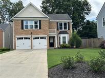 Charming brick home with a two-car garage and well-maintained front lawn at 615 Rosedown Way, Alpharetta, GA 30022