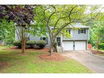 Charming home with a two-car garage, mature trees, and a well-maintained front lawn at 1140 Reading Nw Dr, Acworth, GA 30102
