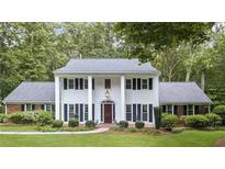 Traditional two-story home with white columns, black shutters, manicured lawn, and mature landscaping at 260 Waverly Hall Dr, Roswell, GA 30075