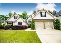 Charming home with a well-manicured lawn, lovely landscaping, and a two-car garage at 1015 Buckeye Ln, Villa Rica, GA 30180