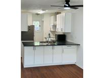 Modern kitchen features white cabinets, dark countertops, and stainless steel appliances at 6662 Witherington Ct, Norcross, GA 30093