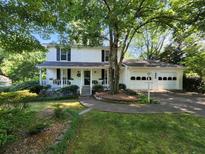 Charming two-story home with a well-manicured lawn, mature trees, and an attached two car garage at 3054 Whisper Knob Rd, Marietta, GA 30062