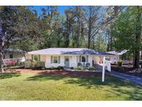 Charming single-story home with a well-manicured lawn and a welcoming front porch with seating at 705 Stewart Nw Cir, Marietta, GA 30064