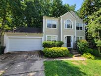 Two-story home featuring manicured landscaping, a two car garage, and traditional architectural design at 180 Preston Oaks Dr, Johns Creek, GA 30022