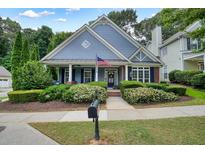 Charming home with blue siding, manicured landscaping, and a welcoming front porch at 400 Pringle Dr, Suwanee, GA 30024