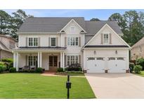 Beautiful two-story home with a manicured lawn, attached two-car garage, and inviting front porch with brickwork at 1860 Leighton Ln, Marietta, GA 30062