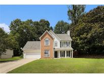 Charming two-story home featuring a brick and siding exterior, landscaped lawn, and attached two-car garage at 228 Kensington Trce, Stockbridge, GA 30281