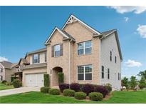Charming two-story brick home featuring a manicured lawn, attached garage, and stylish architectural details at 4710 Robins Nest Ln, Cumming, GA 30041