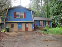 Charming home with blue siding, red shutters, front door, and a driveway approach in a wooded setting at 5398 Rockbridge Rd, Stone Mountain, GA 30088