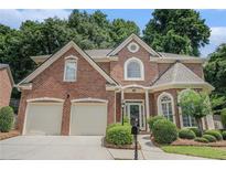 Beautiful brick home with a two-car garage and well-manicured landscaping at 5003 Village Terrace Dr, Dunwoody, GA 30338