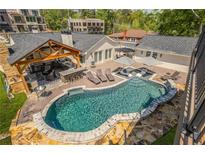 Stunning pool area with an outdoor kitchen and a lounge area for the ultimate entertainment experience at 8175 Main St, Woodstock, GA 30188