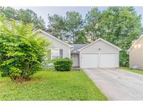 Charming single-Gathering home features a two-car garage, lush lawn, and mature trees at 6304 Kendra Ln, Lithonia, GA 30058