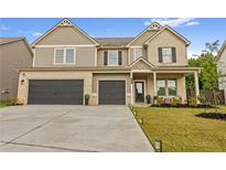 Inviting two-story home with a two-car garage, stone accents, and well-manicured lawn at 116 Eleanora Park, Loganville, GA 30052