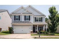 Charming two-story home with a well-manicured lawn, two car garage, and classic architectural details at 319 Nobleman Way, Canton, GA 30114