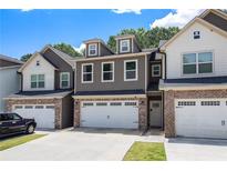 Charming townhome featuring a two-car garage and inviting curb appeal with neutral colors at 7805 Rock Rose Ln, Fairburn, GA 30213
