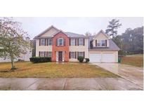 Traditional two-story home with a two-car garage, symmetrical design and landscaped front yard at 1857 Oak Hill Springs Blvd, Lithonia, GA 30058