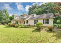 Charming single-Gathering home featuring a lush green lawn, mature trees, and classic curb appeal at 1050 Birdseye Vw, Locust Grove, GA 30248