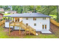 Expansive backyard view showcasing a new wooden deck and a painted brick house exterior at 2720 Cavalier Dr, Decatur, GA 30034
