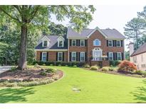 Beautiful two-story brick home with a lush green lawn and mature trees in a desirable neighborhood at 366 Coopers Pond Dr, Lawrenceville, GA 30044