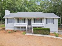 Charming home with a cozy front porch, black shutters, and a well-maintained lawn at 5045 Shadow Wood Dr, Canton, GA 30114