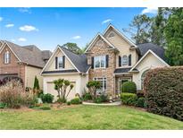 Charming two-story home featuring stone accents and a well-manicured front lawn and beautiful landscaping at 994 Fairview Club Cir, Dacula, GA 30019