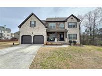 Stunning two-story brick home with a well-manicured lawn and attached two-car garage at 719 Lilac Mist Dr, Loganville, GA 30052