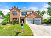 Charming two-story brick home featuring a well-maintained lawn, two-car garage, and inviting front entrance at 1777 Cutters Mill Way, Lithonia, GA 30058
